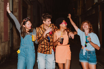 Friends going out in the evening and making party. Young people meeting outdoor in the weekend and celebrating together.