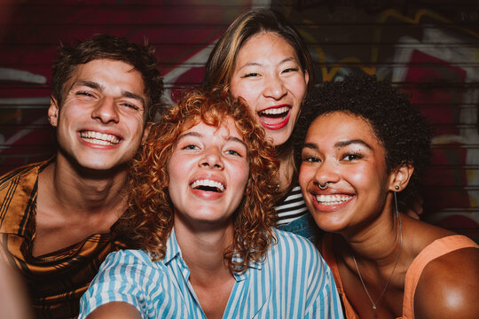 Friends going out in the evening and making party. Young people meeting outdoor in the weekend and celebrating together.