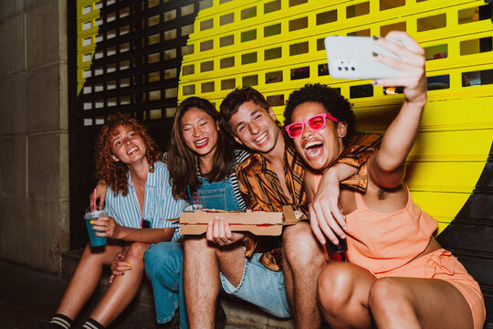 Friends going out in the evening and making party. Young people meeting outdoor in the weekend and celebrating together.