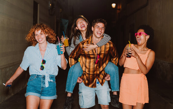 Friends going out in the evening and making party. Young people meeting outdoor in the weekend and celebrating together.
