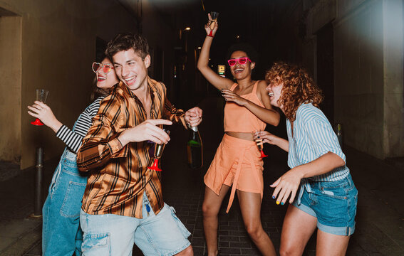 Friends going out in the evening and making party. Young people meeting outdoor in the weekend and celebrating together.