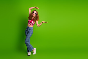 Happy young woman posing with joyful gestures against a vibrant green background