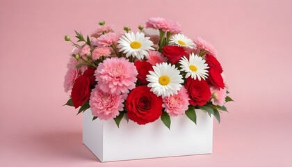 Un ramo de flores coloridas que incluyen rosas rojas, claveles rosados ​​y margaritas blancas en una caja de regalo blanca sobre un fondo rosa