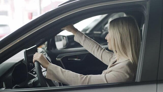 Woman enjoys a slow motion test drive in a car showroom while contemplating a purchase experience