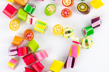 closeup on white background in a small multi-colored sugar caramels with different flavors and...
