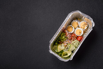 Healthy breakfast consisting of boiled eggs, slices of ham, tomatoes, green beans, aioli sauce