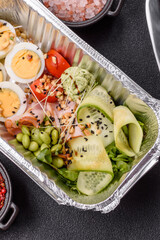 Healthy breakfast consisting of boiled eggs, slices of ham, tomatoes, green beans, aioli sauce