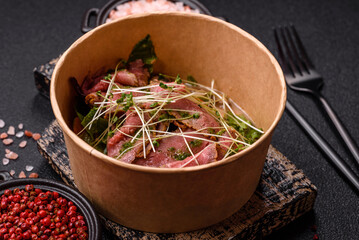 Warm salad consisting of slices of roast beef, greens, tomatoes, cucumbers, green beans