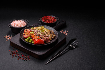 Warm salad consisting of slices of roast beef, greens, tomatoes, cucumbers, green beans