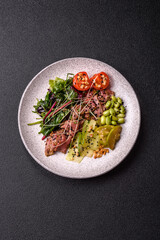 Warm salad consisting of slices of roast beef, greens, tomatoes, cucumbers, green beans
