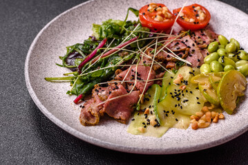 Warm salad consisting of slices of roast beef, greens, tomatoes, cucumbers, green beans
