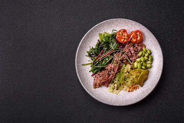 Warm salad consisting of slices of roast beef, greens, tomatoes, cucumbers, green beans
