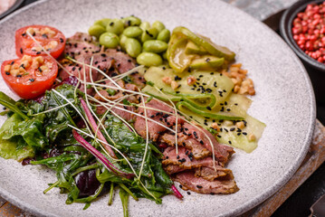 Warm salad consisting of slices of roast beef, greens, tomatoes, cucumbers, green beans