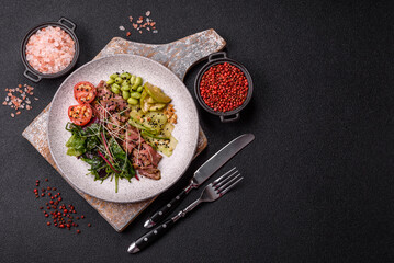 Warm salad consisting of slices of roast beef, greens, tomatoes, cucumbers, green beans