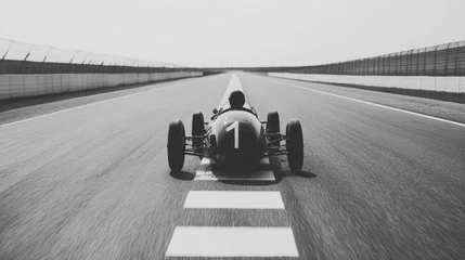  Black and white photo of a vintage race car on a track. © musa