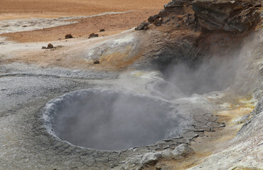 mudpool with colorful sulfuric earth in a geothermal area in Iceland