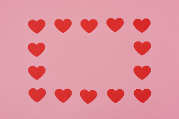 Red hearts pattern, paper cut romantic concept, top view. Beautiful hearts on pastel pink background with copy space. Valentines Day greeting card concept. Flat lay aesthetic..