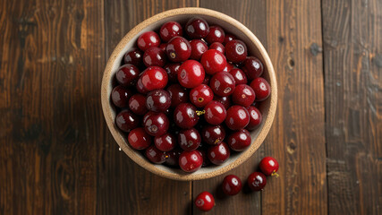 Fresh ripe cranberries in bowl on wooden table, top view
