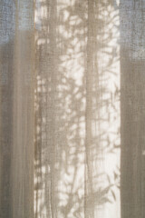 Floral sunlight shadows on a neutral beige linen curtains, aesthetic minimalist natural background...