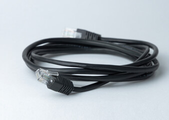 Black ethernet cable lying on a plain surface