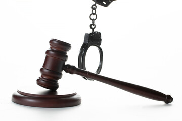Criminal news. A judicial hammer and handcuffs on a white background.
