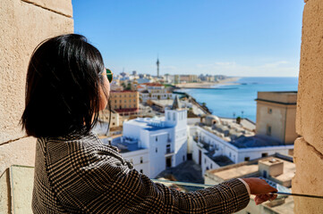 Fototapeta premium Woman looking towards the city of Cadiz