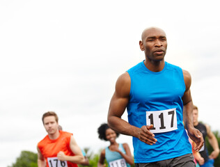 Fitness, running and athletes on track with race, marathon or competition for charity event. Sports, mockup space and group of people with cardio workout, exercise or training at outdoor stadium.