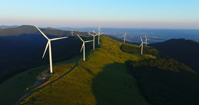 High Capacity Wind Catcher Farm On High Mountain Ridge Sunrise Aerial Orbit