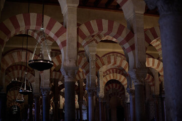 The interior of the Mosque-Cathedral of Córdoba, featuring its iconic columns and horseshoe arches, a masterpiece of Moorish and Spanish architecture in Andalusia, Spain