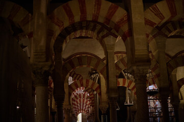 The interior of the Mosque-Cathedral of Córdoba, featuring its iconic columns and horseshoe arches, a masterpiece of Moorish and Spanish architecture in Andalusia, Spain