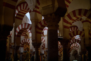 The interior of the Mosque-Cathedral of Córdoba, featuring its iconic columns and horseshoe arches, a masterpiece of Moorish and Spanish architecture in Andalusia, Spain