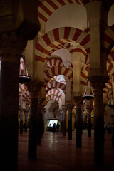 The interior of the Mosque-Cathedral of Córdoba, featuring its iconic columns and horseshoe arches, a masterpiece of Moorish and Spanish architecture in Andalusia, Spain