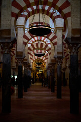 The interior of the Mosque-Cathedral of Córdoba, featuring its iconic columns and horseshoe arches, a masterpiece of Moorish and Spanish architecture in Andalusia, Spain