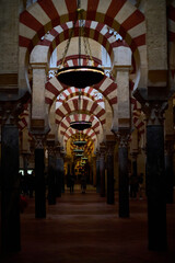 The interior of the Mosque-Cathedral of Córdoba, featuring its iconic columns and horseshoe arches, a masterpiece of Moorish and Spanish architecture in Andalusia, Spain