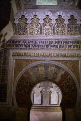 The mihrab of the Mosque-Cathedral of Córdoba, an exquisite example of Moorish artistry, featuring intricate arabesques and golden mosaics in Andalusia, Spain