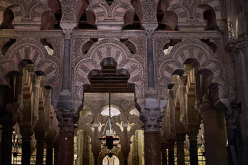 The interior of the Mosque-Cathedral of Córdoba, featuring its iconic columns and horseshoe arches, a masterpiece of Moorish and Spanish architecture in Andalusia, Spain
