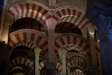 The interior of the Mosque-Cathedral of Córdoba, featuring its iconic columns and horseshoe arches, a masterpiece of Moorish and Spanish architecture in Andalusia, Spain