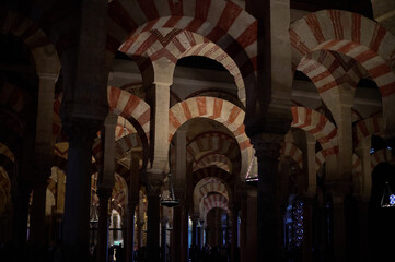 The interior of the Mosque-Cathedral of Córdoba, featuring its iconic columns and horseshoe arches, a masterpiece of Moorish and Spanish architecture in Andalusia, Spain