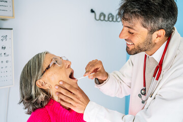 Doctor performing oral examination on senior woman in clinic
