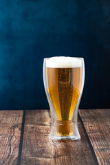 Golden Beer with Bubbles and Foam Served in a Double-Layer Thermal Glass on an Elegant Background – Premium Presentation