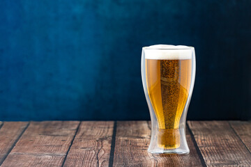 Golden Beer with Bubbles and Foam Served in a Double-Layer Thermal Glass on an Elegant Background – Premium Presentation