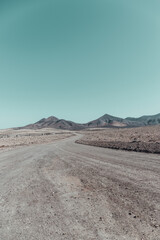 Strange, lunar landscape of the Fuerteventura volcanos and dirt roads in the interior of the island. Mountains, sands
