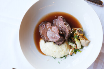 Braised meat with creamy mashed potatoes and sautéed vegetables
