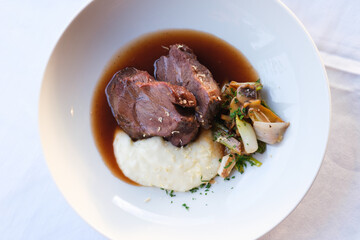 Braised meat with creamy mashed potatoes and sautéed vegetables