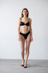 Obraz premium High-quality model polaroid featuring a tall, fit woman in a minimalistic studio environment. Showcasing a neutral expression, toned physique, and poised posture for fashion industry standards.