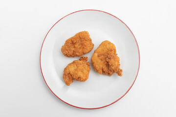 Fried chicken wings on a plate on a white background, close-up