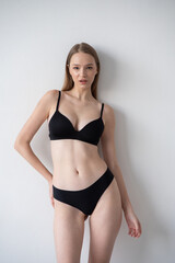 Fototapeta premium Casting snapshot of a fresh-faced model in simple black underwear, highlighting her natural features, body proportions, and confident stance. Ideal for agency scouting and professional portfolio updat