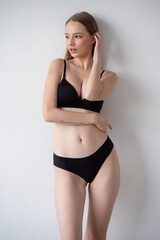 Fototapeta premium Casting snapshot of a fresh-faced model in simple black underwear, highlighting her natural features, body proportions, and confident stance. Ideal for agency scouting and professional portfolio updat