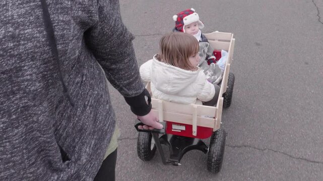 Lady POV Pulling Children in Red Wagon