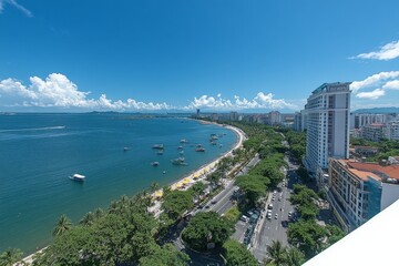 Obraz premium Vibrant coastal view of a bustling beach with boats and city skyline under clear blue sky